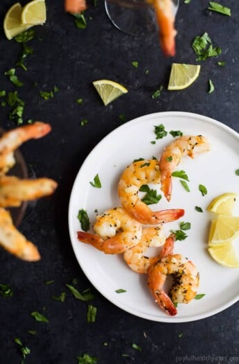 Easy 10 Minute Garlic Herb Roasted Shrimp served with a homemade Cocktail Sauce. These Roasted Shrimp are the ultimate Holiday Party Appetizer! So put that flavorless cocktail shrimp down and make these! I guarantee you'll fall in love!