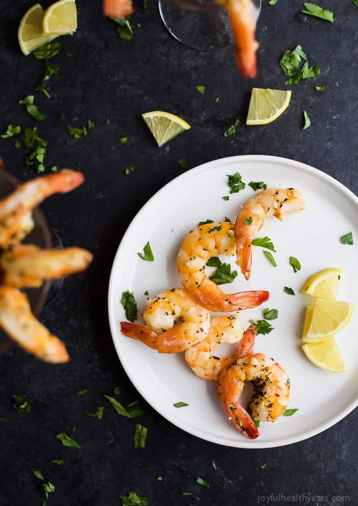 Easy 10 Minute Garlic Herb Roasted Shrimp served with a homemade Cocktail Sauce. These Roasted Shrimp are the ultimate Holiday Party Appetizer! So put that flavorless cocktail shrimp down and make these! I guarantee you'll fall in love!