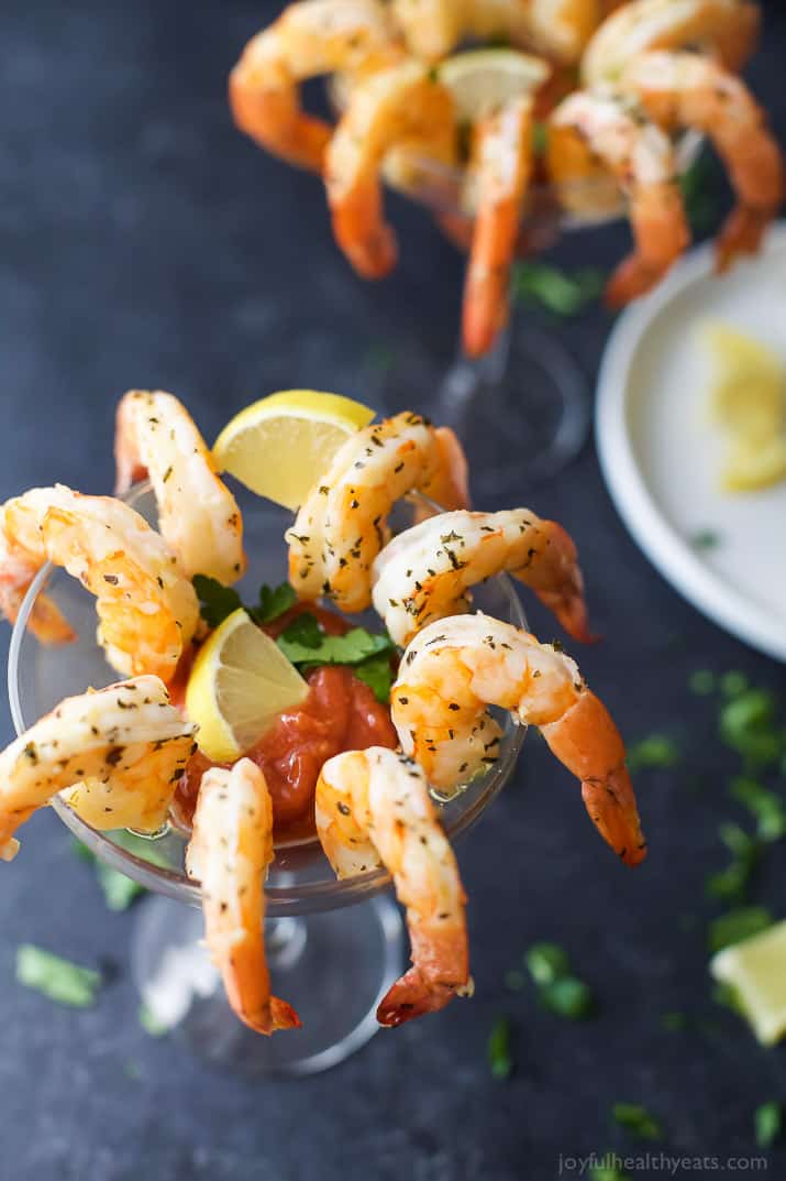 Top view of Garlic Herb Roasted Shrimp around the rim of a glass with cocktail sauce