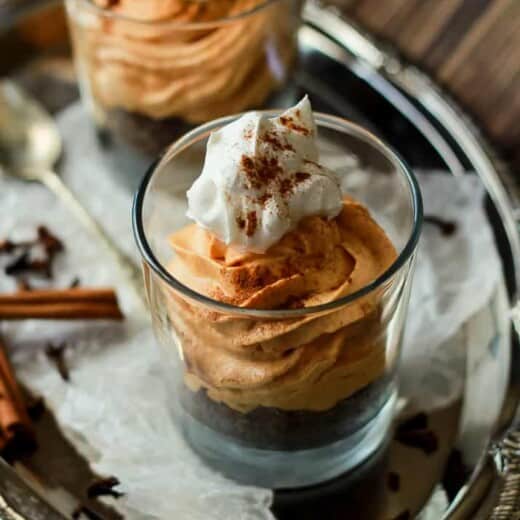 A Close-Up Shot of a No Bake Pumpkin Cheesecake in a Glass on Top of a Serving Platter