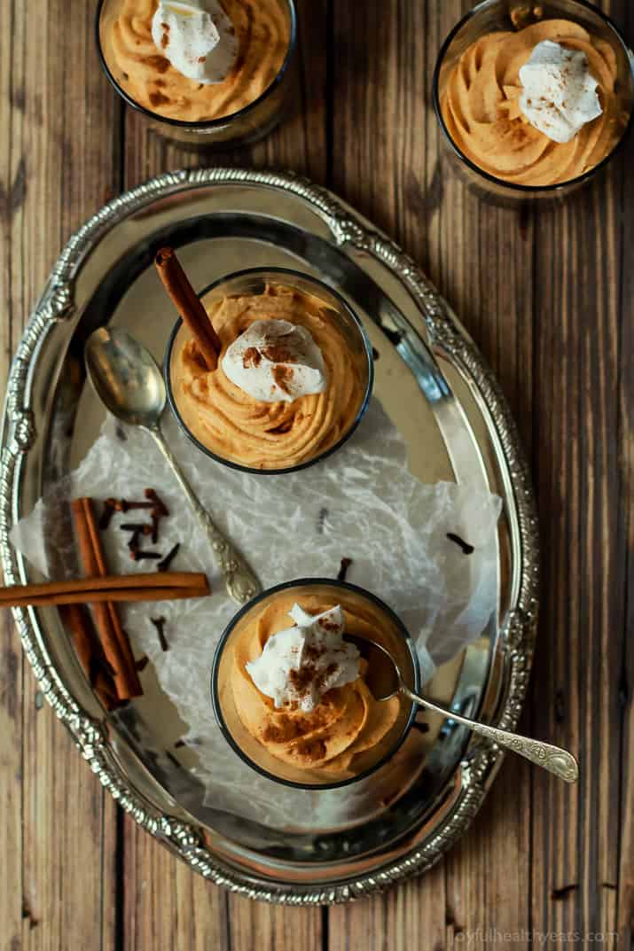 Two No-Bake Pumpkin Cheesecakes on a Metal Serving Platter with Two Cinnamon Sticks