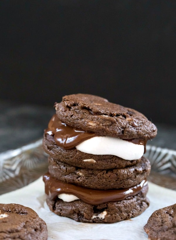 Two Hot Chocolate Sandwich Cookies Stacked on Top of Parchment Paper