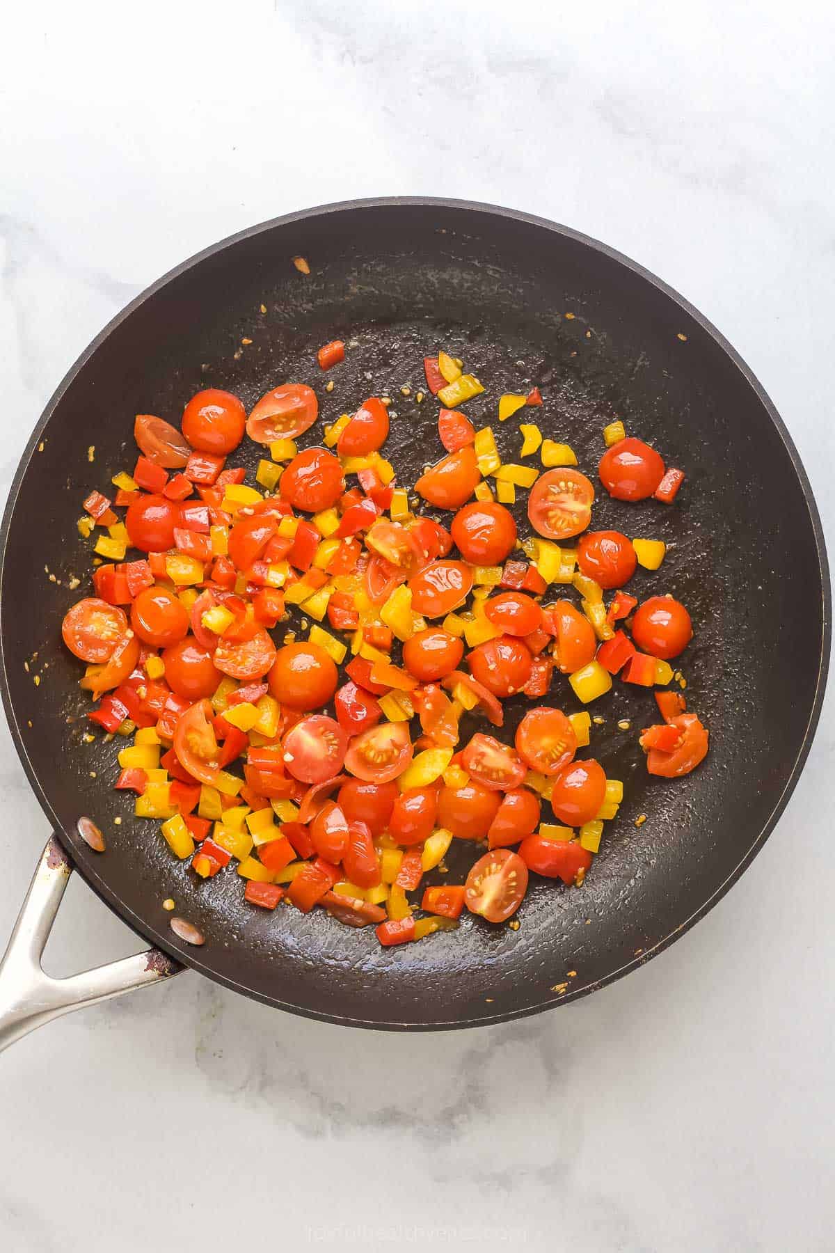 Cooking the tomatoes in the pan. 