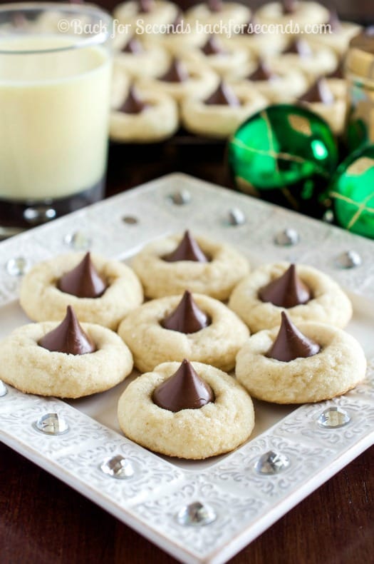 A Plate of Eggnog Cookies Next to Two Green Christmas Ornaments