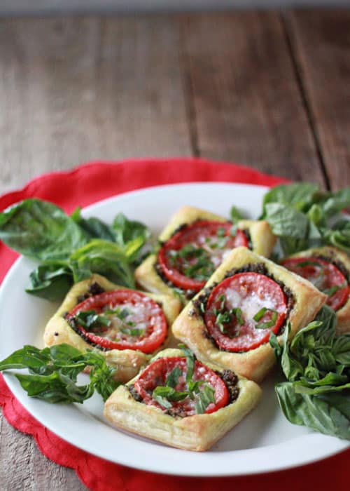 Five Tomato Pesto Tarts on a Plate on Top of a Red Doiley