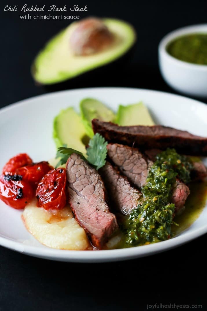 Slices of Chili Rubbed Flank Steak with chimichurri sauce on a plate