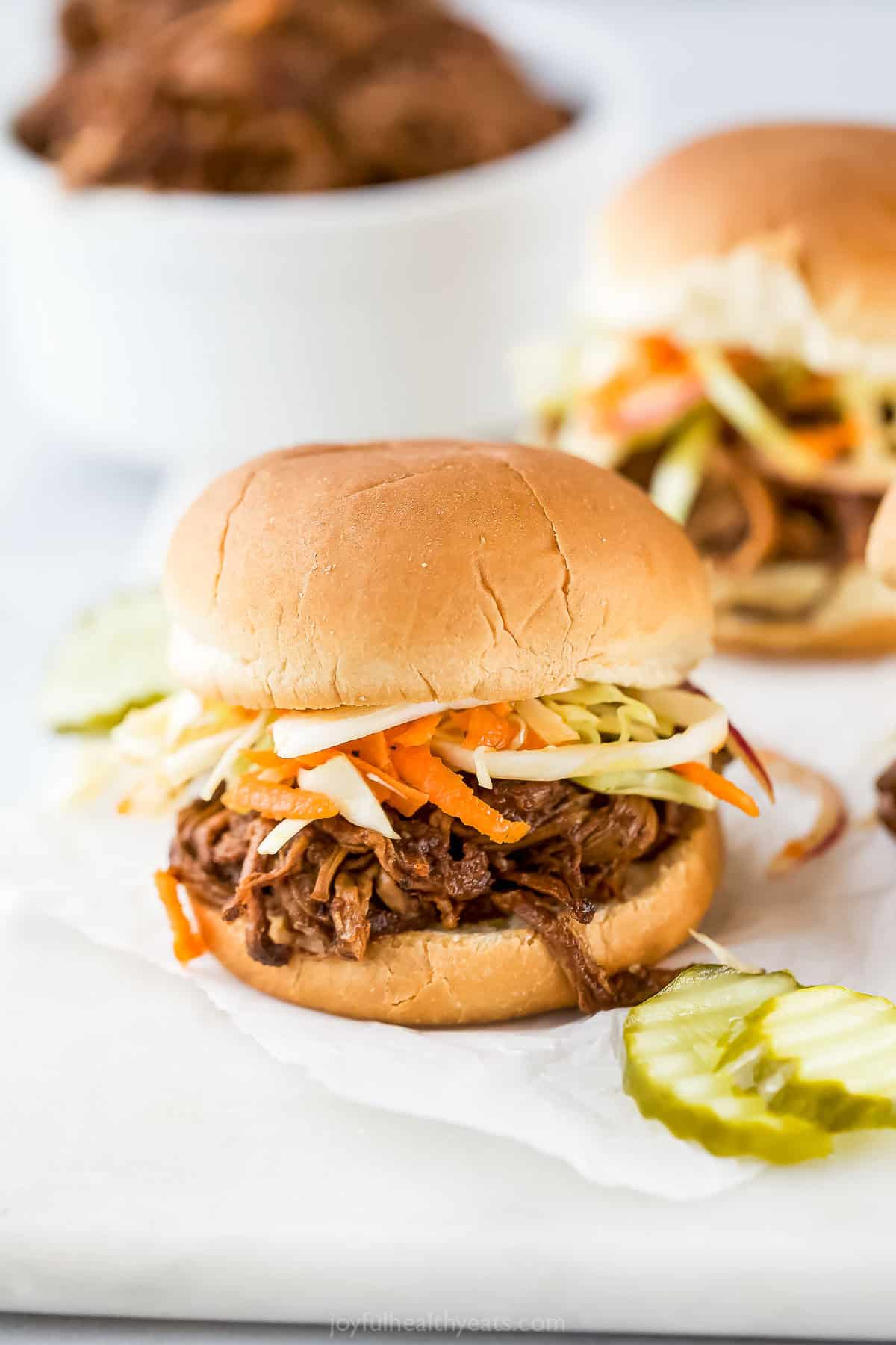 Pulled pork slider topped with carrot and cabbage slaw.