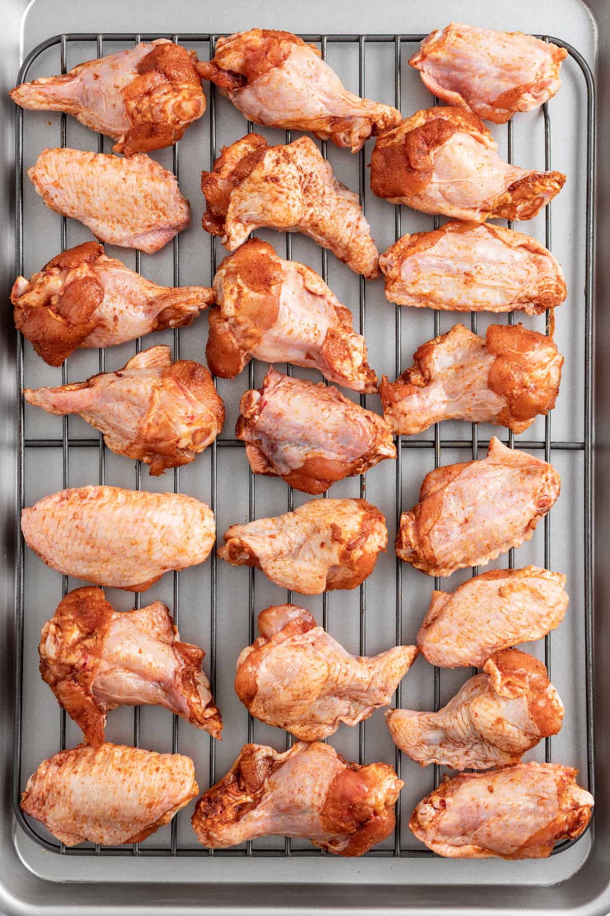 raw chicken wings on a cooling rack
