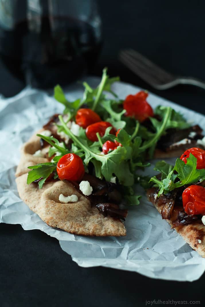 Pita pizza with balsamic caramelized onions, feta, arugula and tomatoes