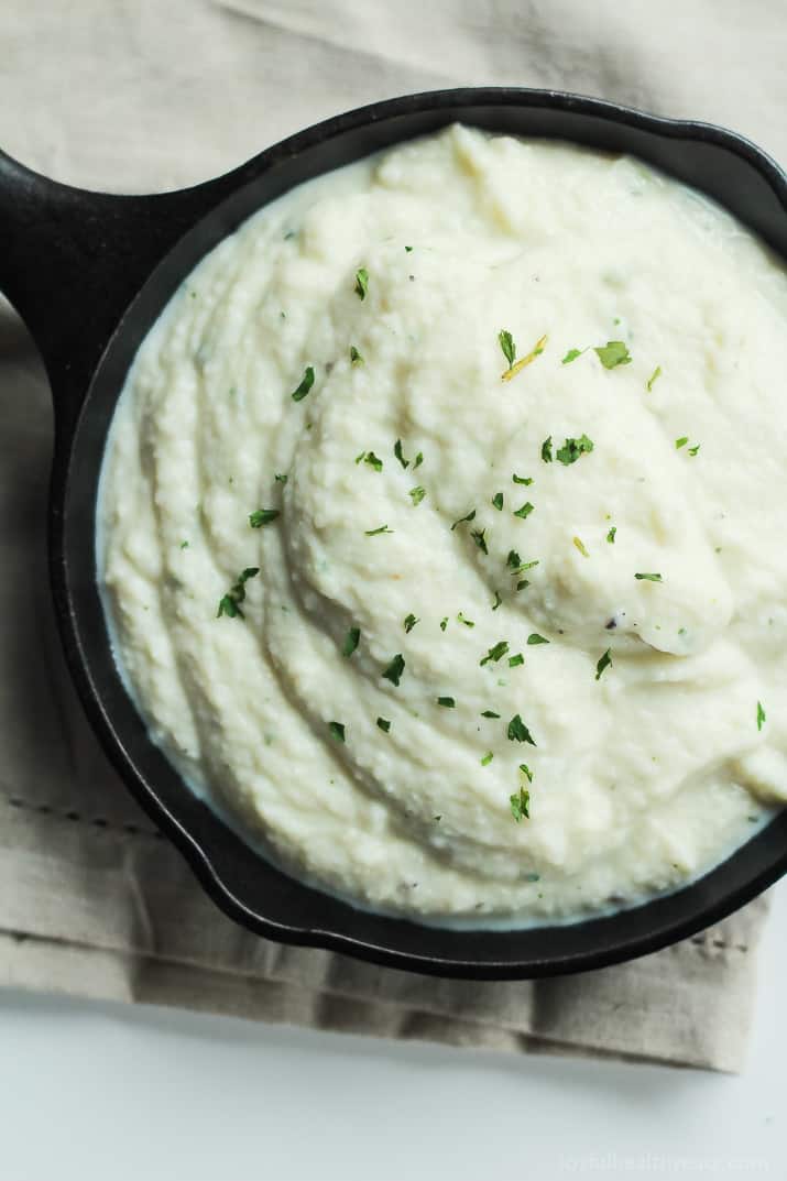 A Close-up View of Cauliflower Alfredo Sauce in a Small Black Skillet