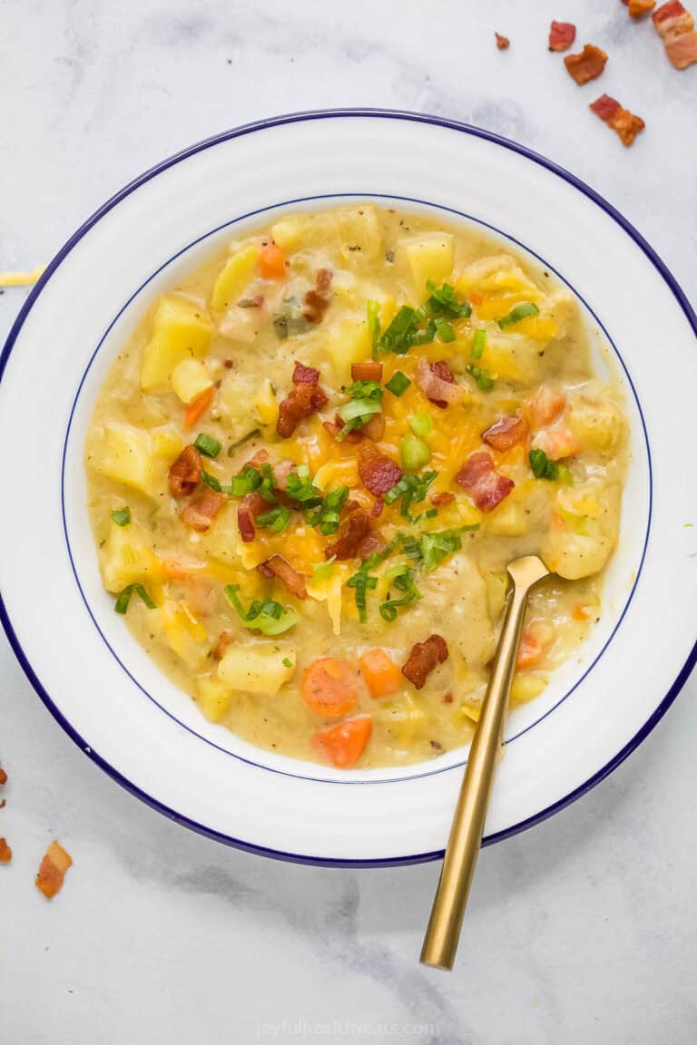 Overhead view of creamy potato leek soup in bowl with spoon
