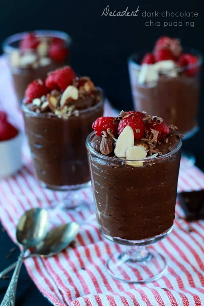Dessert glasses of Decadent Dark Chocolate Chia Pudding, topped with sliced almonds, shaved chocolate and fresh raspberries