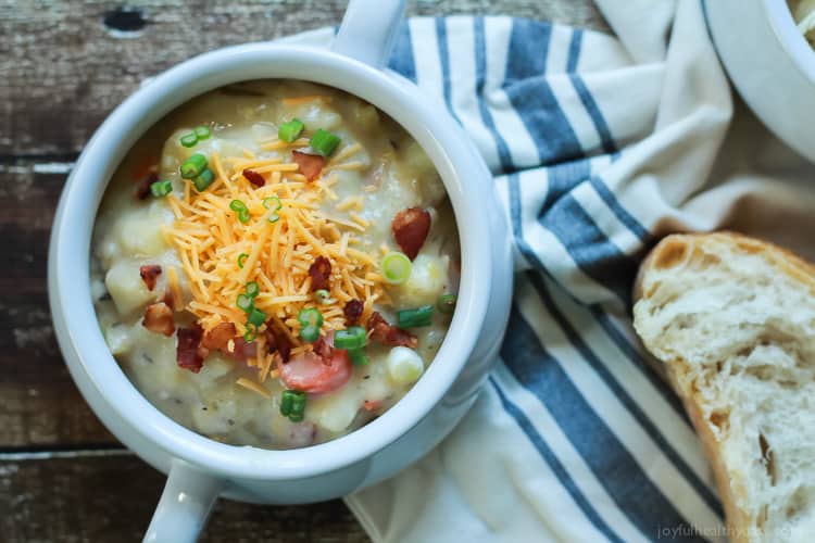 Top view of a crock of Creamy Potato Leek Soup and a piece of crusty bread
