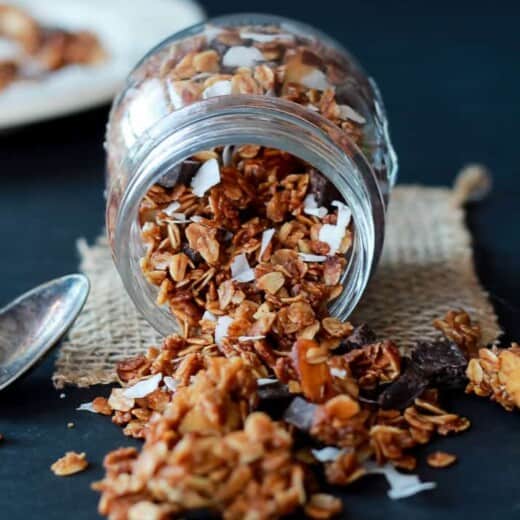 A Jar On its Side Pouring Out Homemade Almond Joy Granola