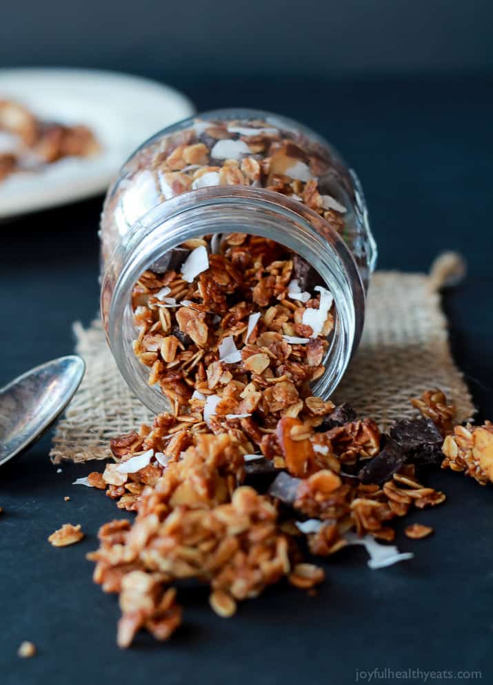 a jar spilling granola onto a blue table setting