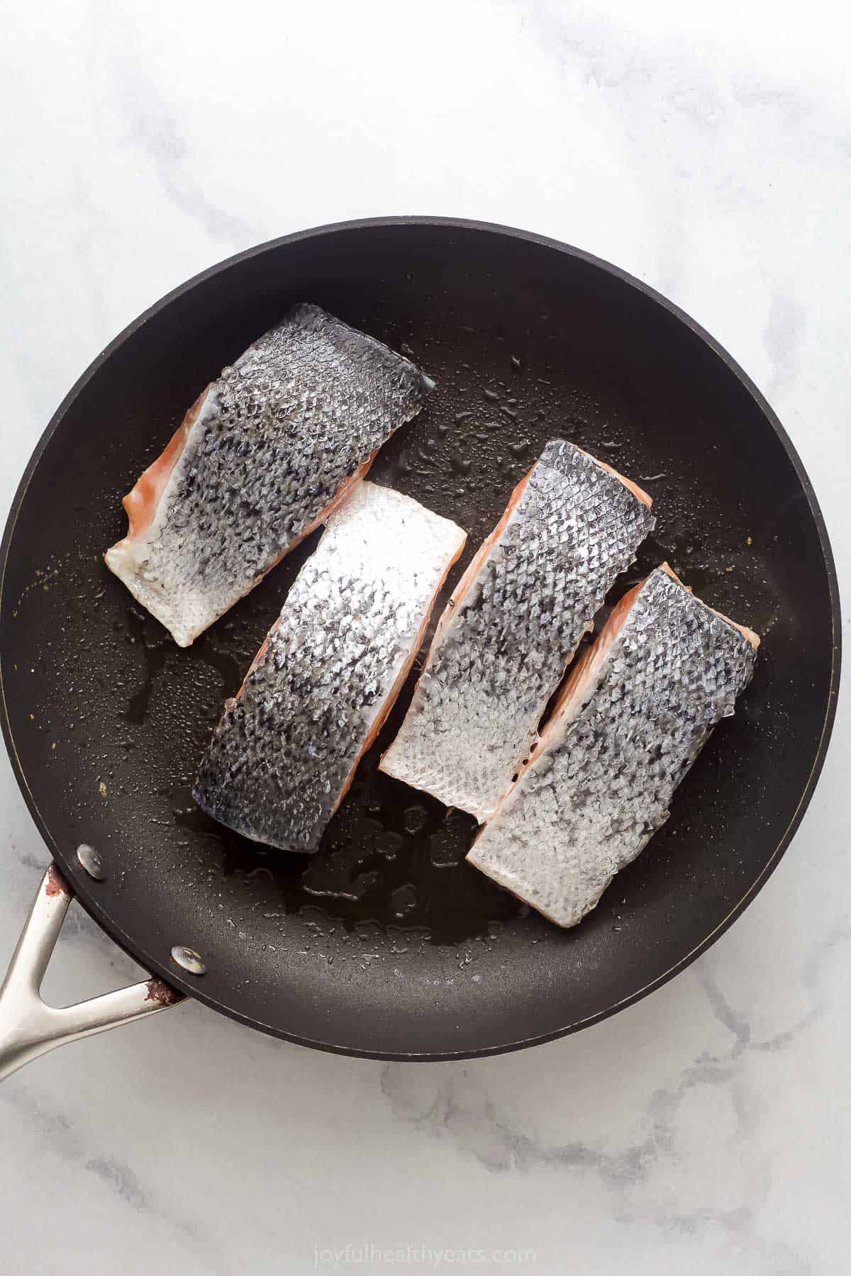 Searing the salmon with the skin facing upwards.