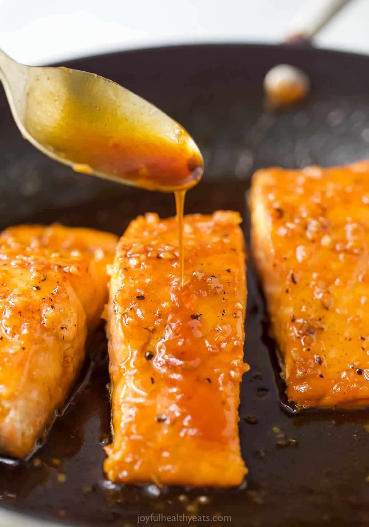 Spooning the sauce over the salmon. 