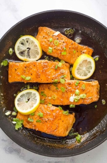 Four salmon fillets with glaze in the pan.