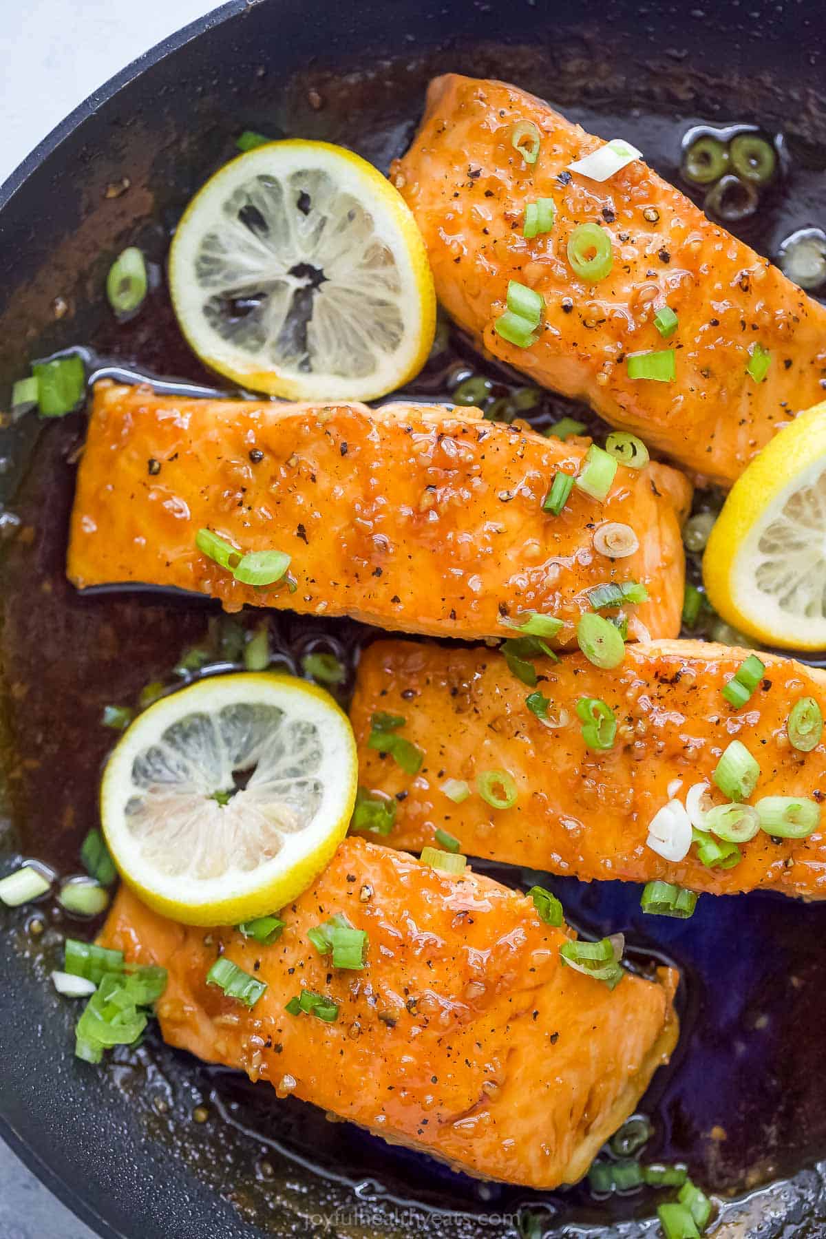 Salmon fillets with honey glaze in the skillet. 