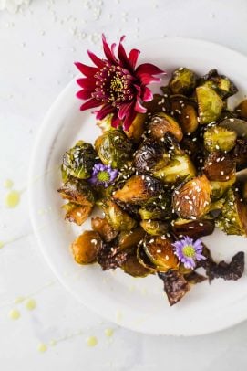 honey soy roasted brussels sprouts on a plate with flowers