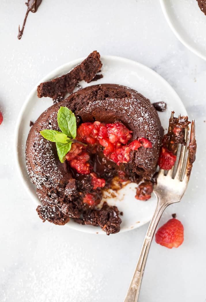 photo of half eaten nutella chocolate lava cake topped with champagne muddled raspberries