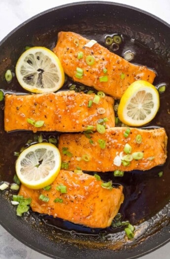 Four salmon fillets with glaze in the pan.