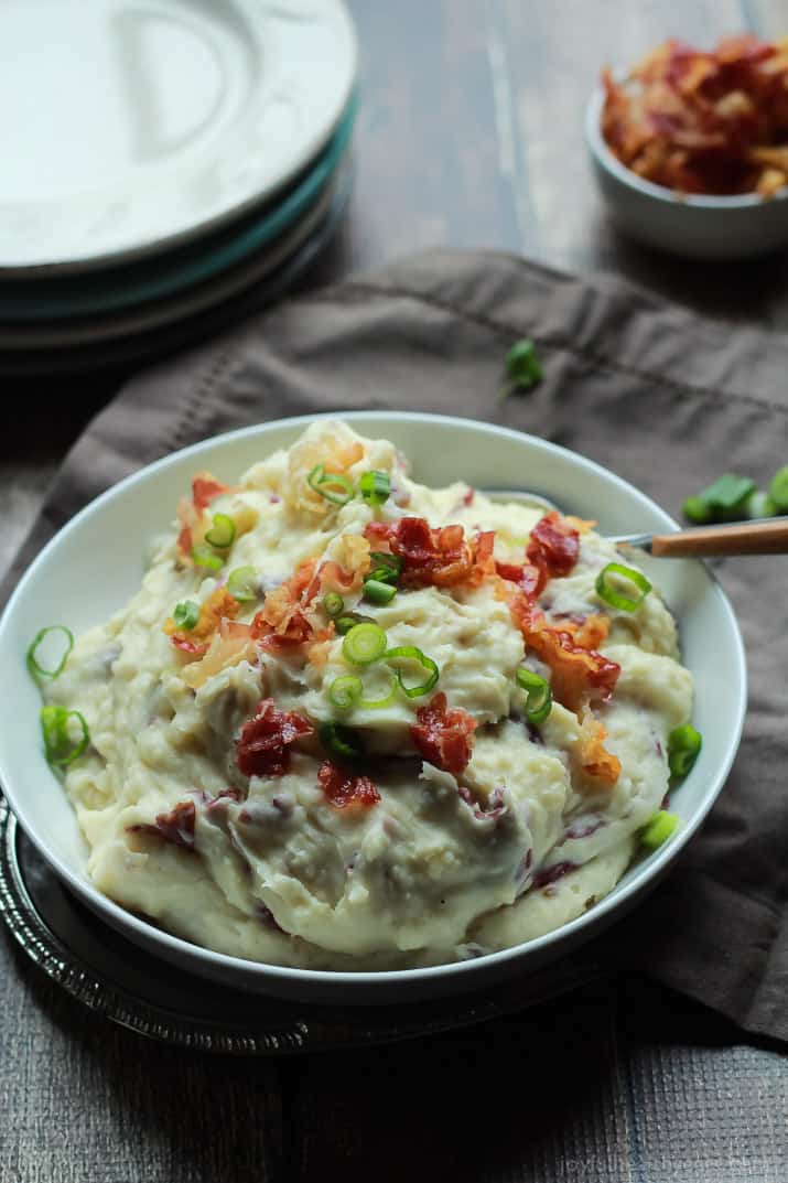 A White Bowl Containing Creamy Goat Cheese Mashed Potatoes and a Spoon with a Wooden Handle