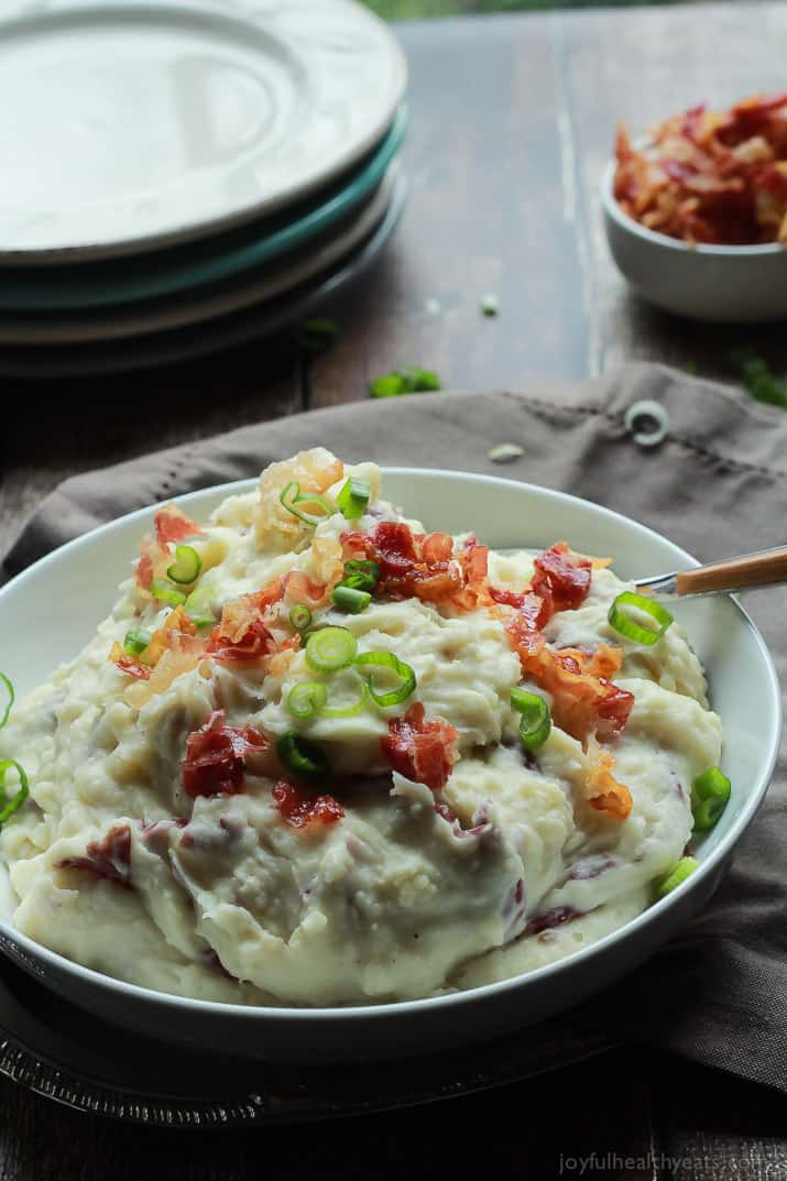 A Bowl of Mashed Potatoes Next to a Stack of Plates and Additional Pancetta