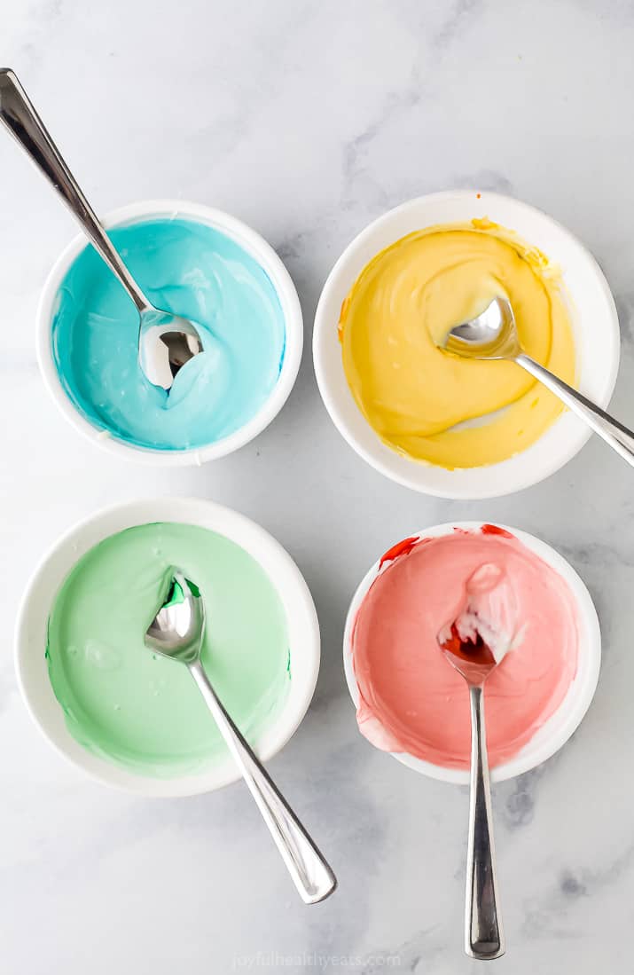 four bowls with pastel colored chocolates