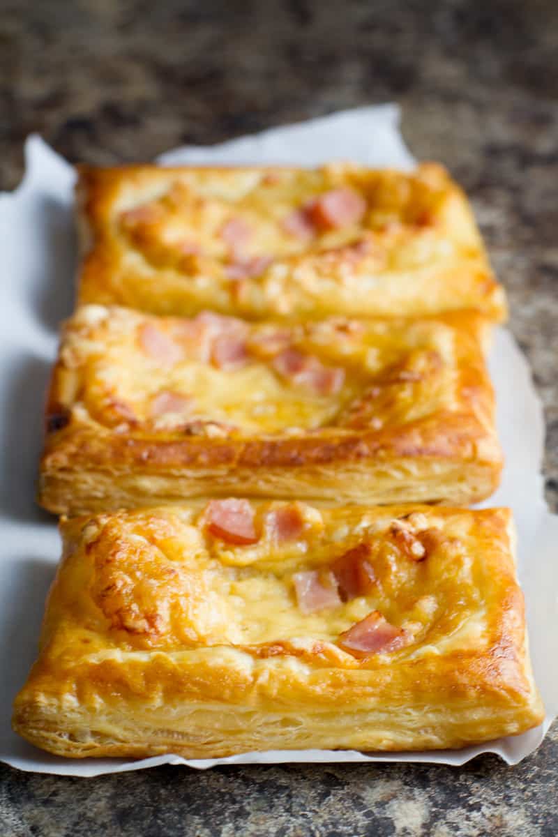 Three Canadian Bacon and Cheese Savory Tarts on a Piece of Parchment Paper