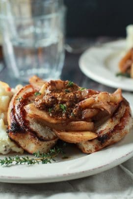 Mustard Crusted Pork Chops with Bourbon Glazed Apples on a white plate