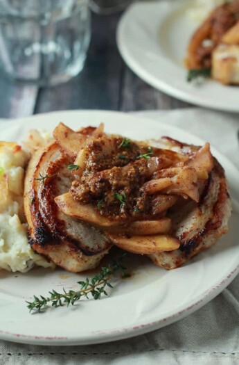 Mustard Crusted Pork Chops with Bourbon Glazed Apples on a White Plate