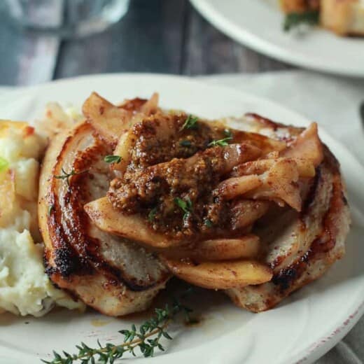 Mustard Crusted Pork Chops with Bourbon Glazed Apples on a White Plate