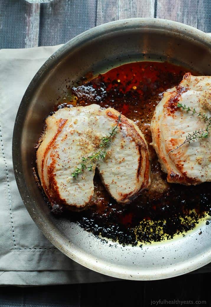 Two Juicy Pork Chops Searing in a Metal Skillet