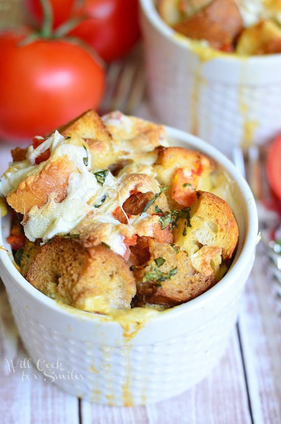 Savory Tomato Basil Bread Pudding in a Ramekin Next to Three Tomatoes