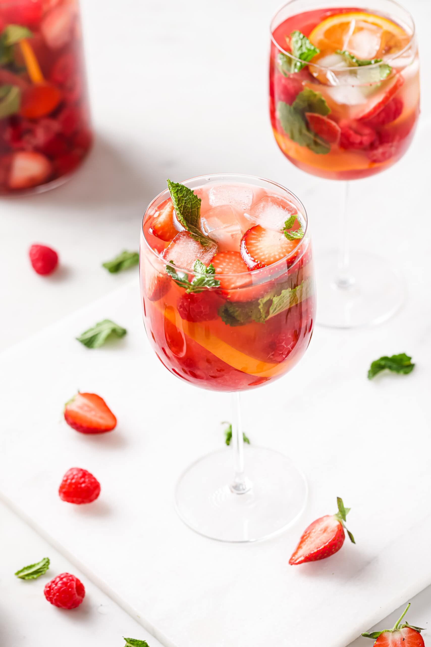 Glass of strawberry rose sangria with ice and mint. 