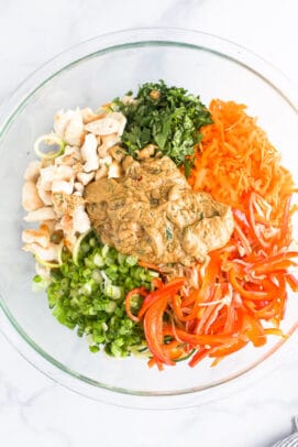 With juicy pan-seared Thai chicken, loads of fresh veggies, and a zesty peanut sauce, this 20-minute dinner is guaranteed to be a favorite! Vegetables and chicken in bowl with peanut sauce.
