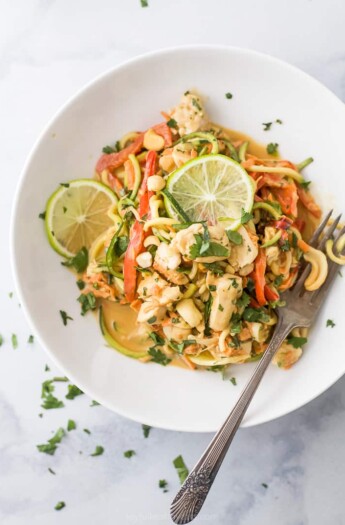 closeup photo of thai chicken zucchini noodles with spicy peanut sauce in a bowl