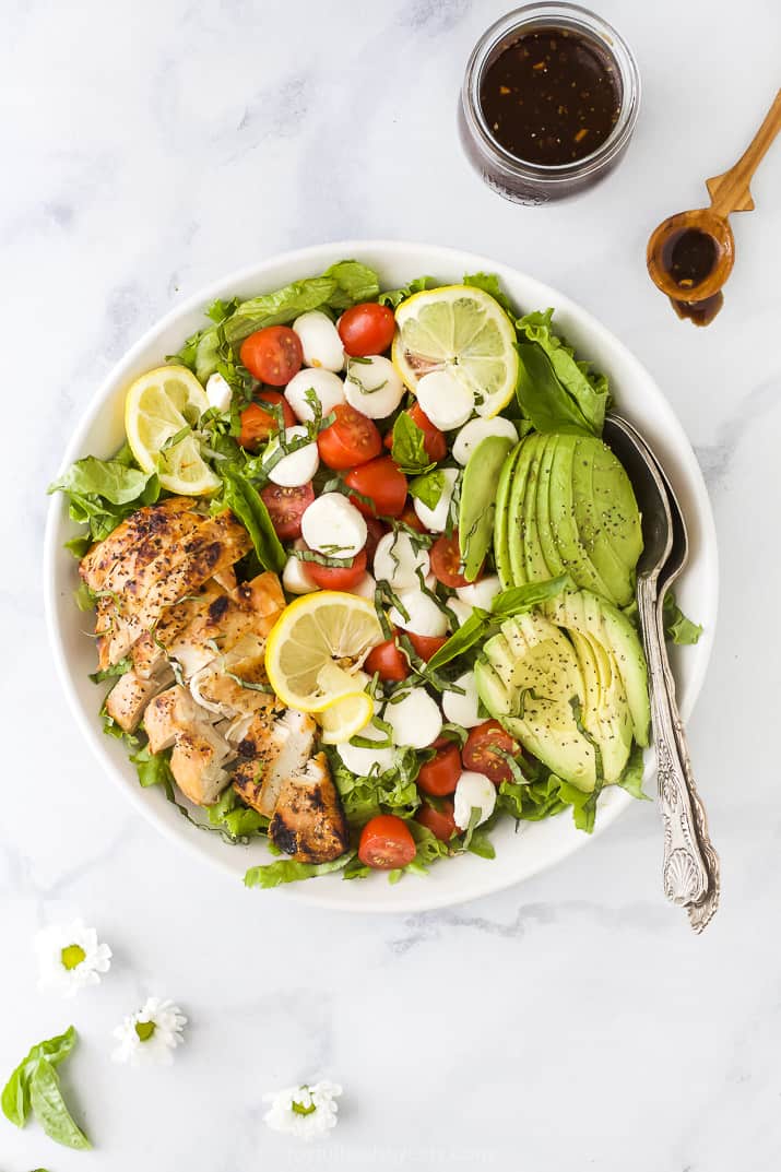 overhead photo of avocado caprese chicken salad in a bowl with balsamic vinaigrette