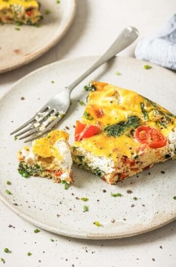 Cheesy bacon spinach frittata on plate with fork