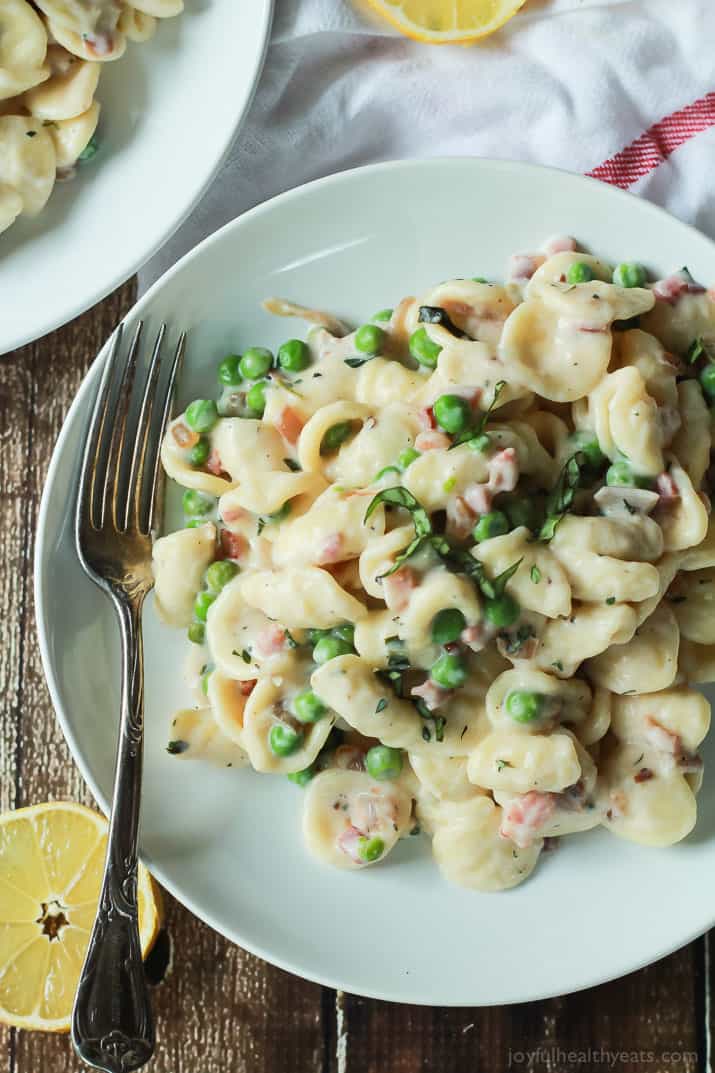 Crispy Pancetta Sweet Pea Orecchiette Pasta tossed with a creamy lemon herb Goat Cheese Sauce! This pasta recipe is comfort food to the max AND its skinny! | joyfulhealthyeats.com #recipes 