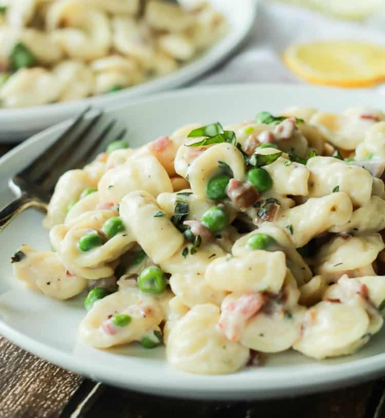 Crispy Pancetta Sweet Pea Orecchiette Pasta tossed with a creamy lemon herb Goat Cheese Sauce! This pasta recipe is comfort food to the max AND its skinny! | joyfulhealthyeats.com #recipes