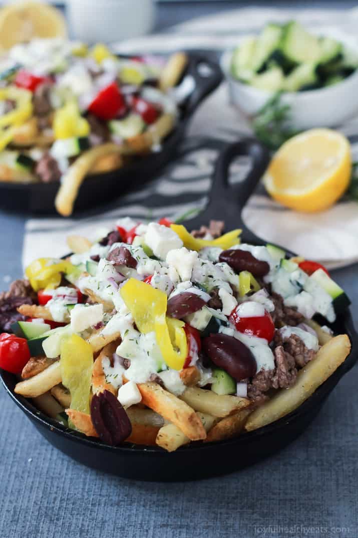 Skinny Greek Loaded French Fry Nachos, an easy creative appetizer recipe that will wow your guests and only takes 25 minutes to make! Filled with homemade tzatziki sauce, ground lamb, and fresh vegetables! | joyfulhealthyeats.com #recipes #SpringIntoFlavor #ad