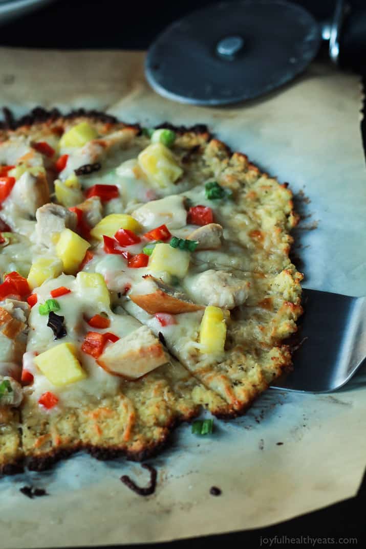 Thai Chili Chicken Pizza with a Cauliflower Crust, topped with a Sweet Spicy Thai Chili Sauce, fresh pineapple, bell peppers, and chicken. An easy gluten free pizza recipe that will be on your table in 25 minutes! | joyfulhealthyeats.com #recipes 