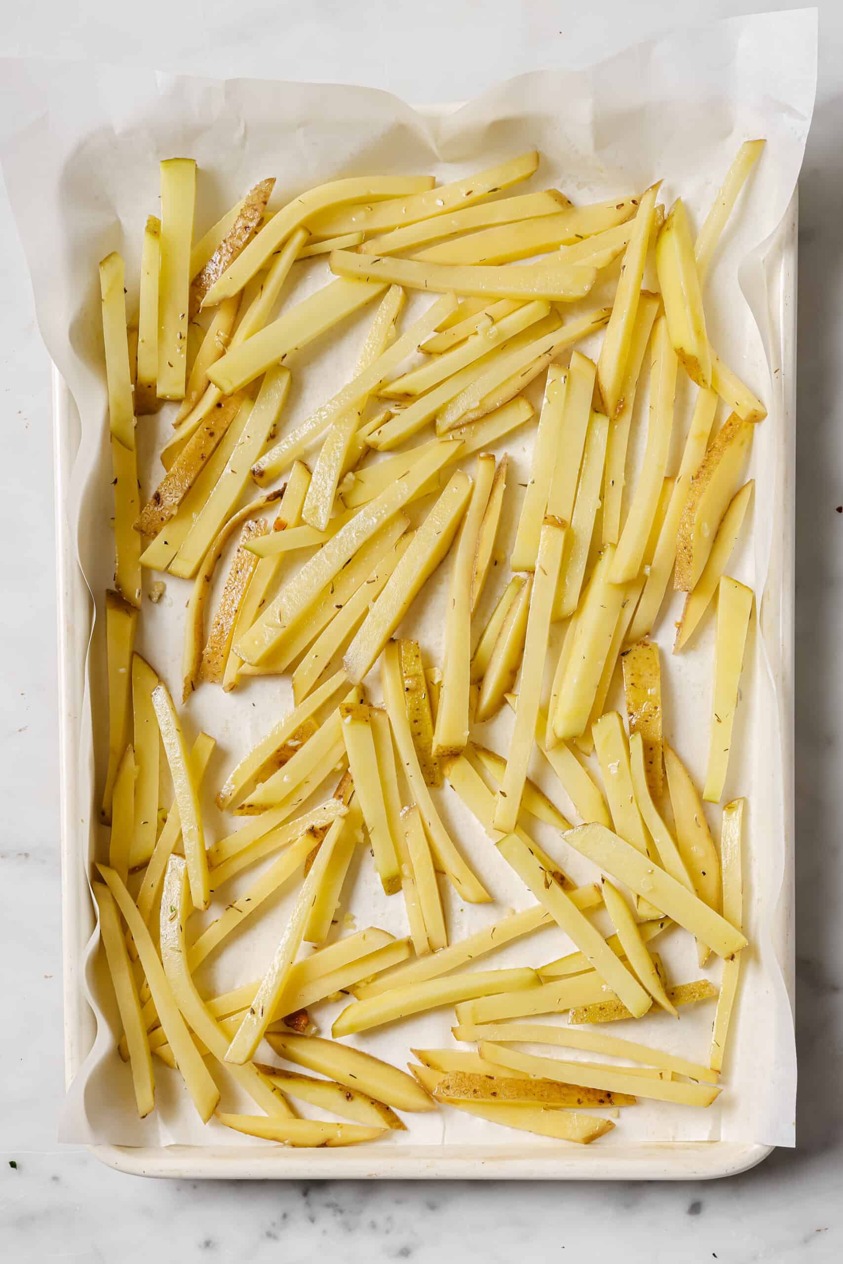 Arranging the potatoes in the lined baking tray.