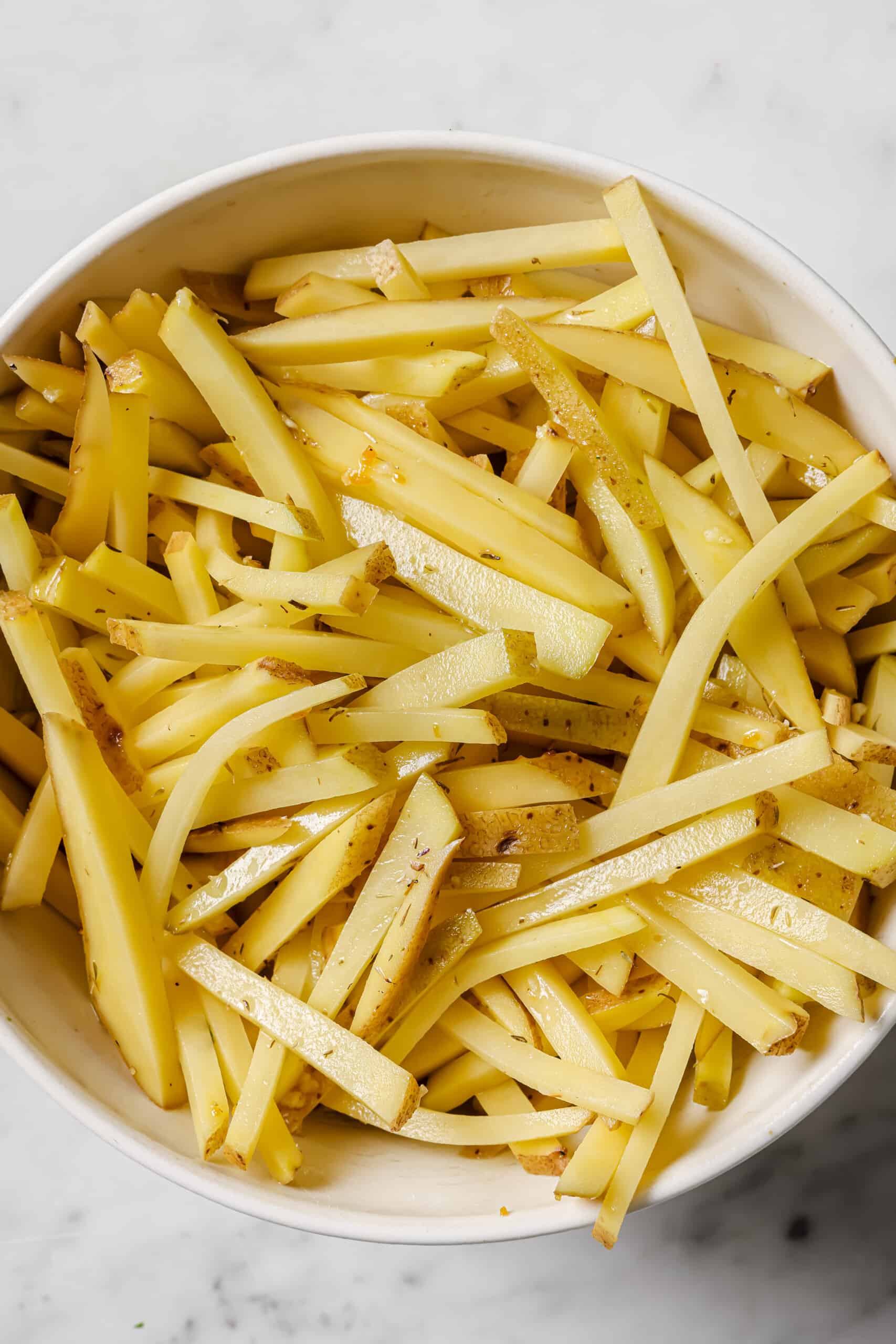 Tossing the potatoes with olive oil and garlic.