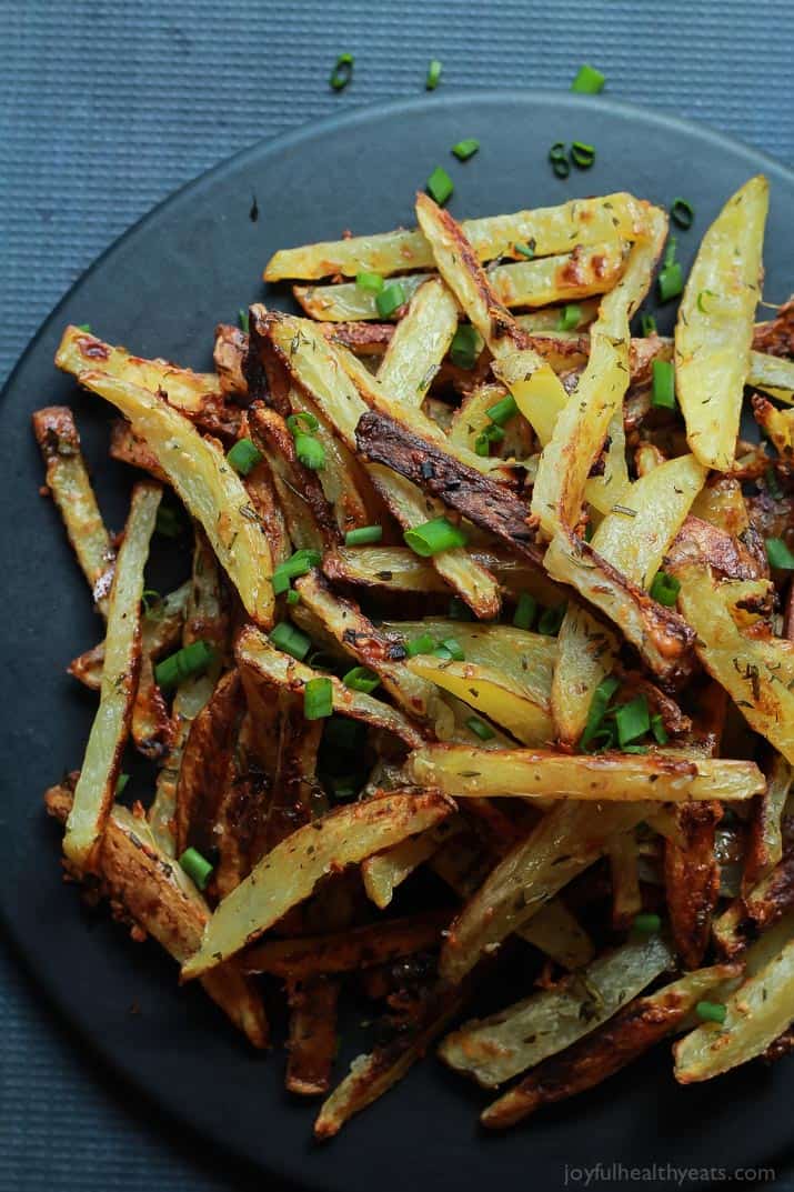 Top view of Crispy Baked Garlic Parmesan Fries with scallions on a plate