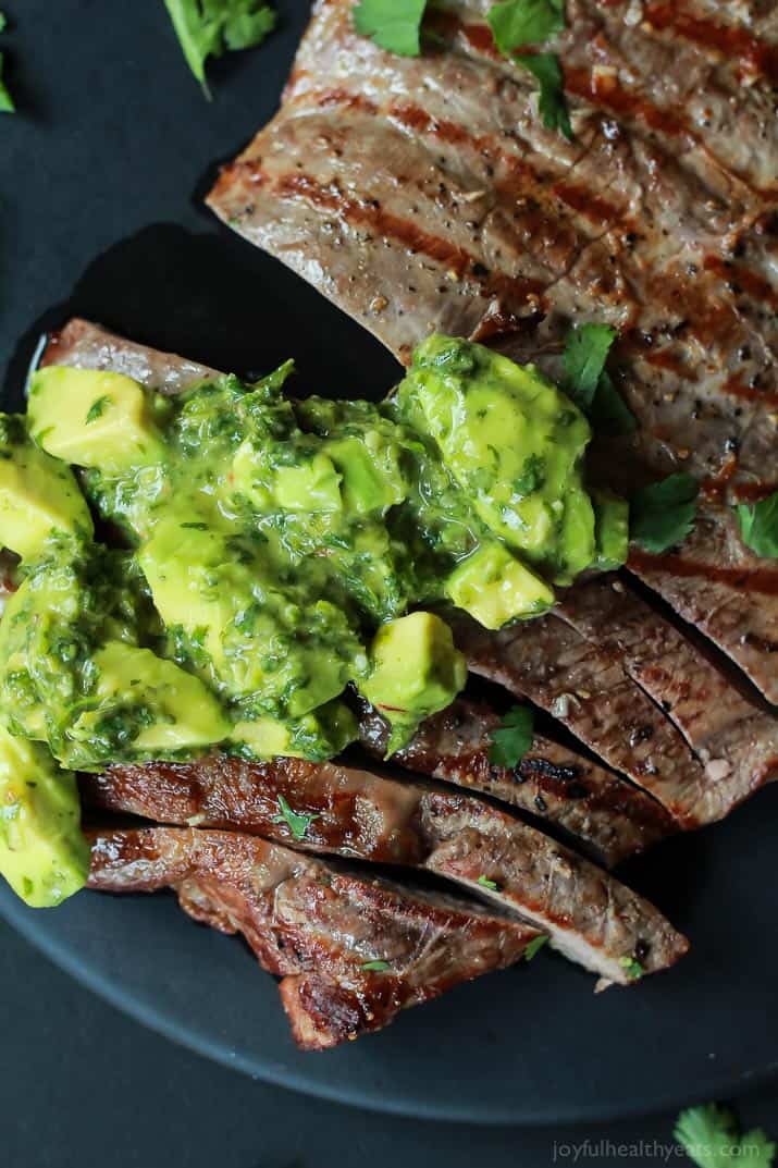 Sliced grilled Flank Steak with fresh Chimichurri sauce on top