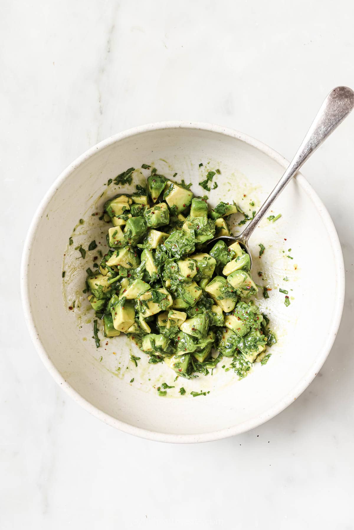 This juicy Grilled Flank Steak with Avocado Chimichurri is an easy recipe that’s full of flavor. It’s ready in less than 20 minutes! Overhead view of avocado chimichurri in bowl with spoon
