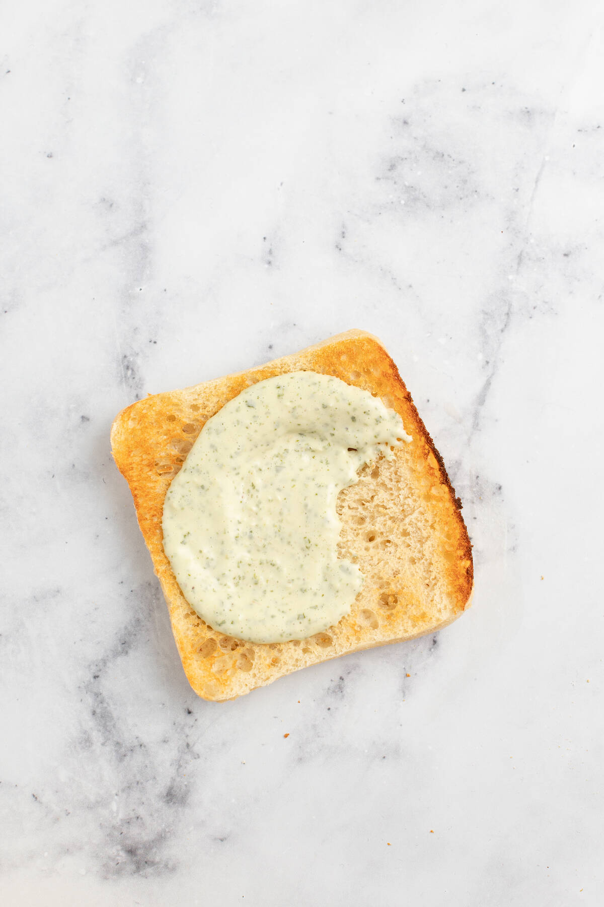 Spreading the bread with basil pesto aioli.